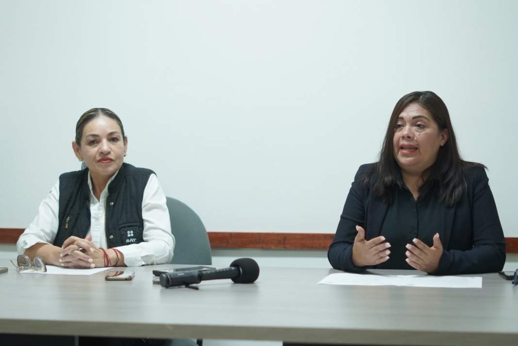 Persona revisa documentos fiscales para regularizar adeudos ante el SAT.