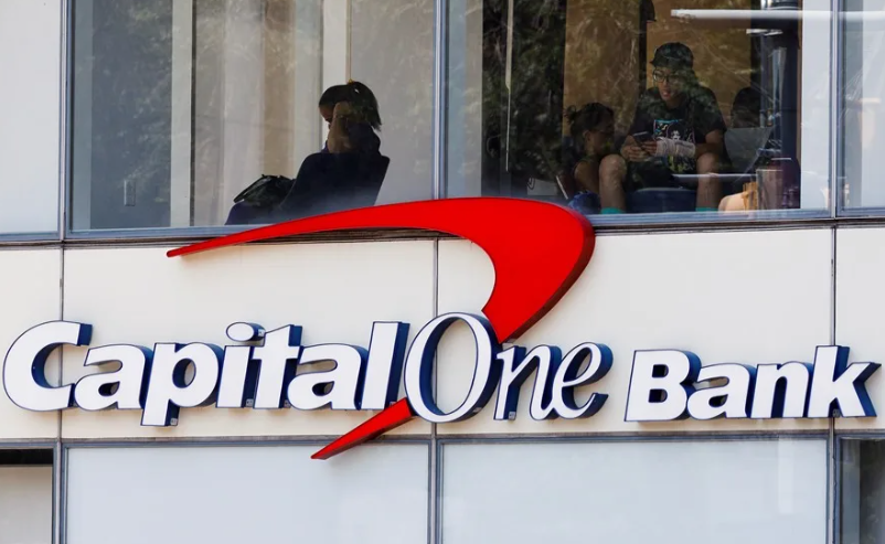 Donald Trump durante un evento público junto al logo de Capital One.