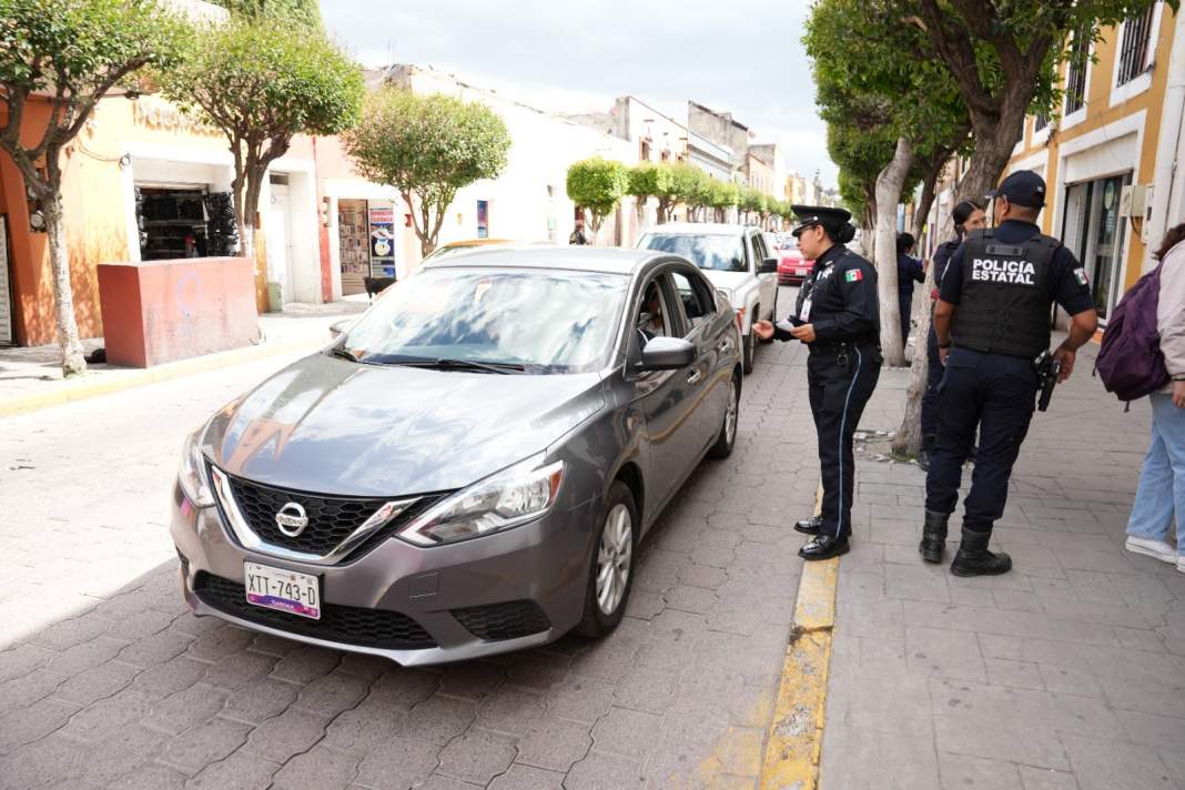Patrulla de seguridad vigilando vehículos estacionados en Tlaxcala.