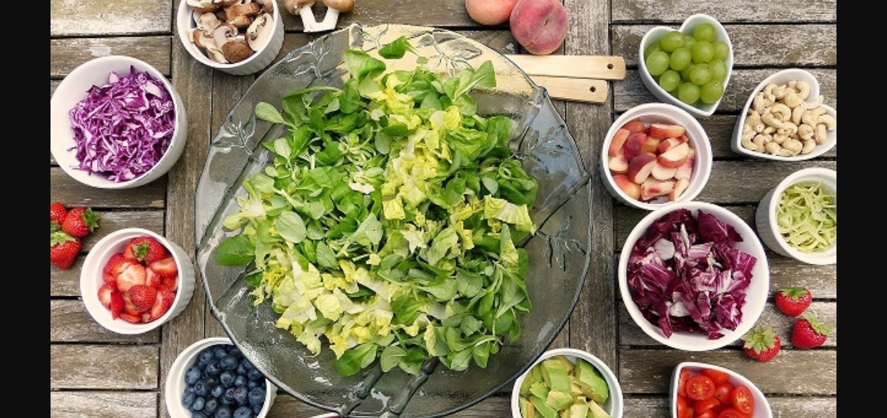 Persona midiendo su glucosa junto a alimentos saludables.