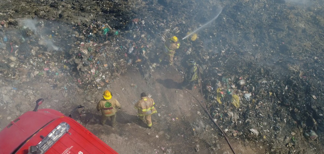 Bomberos trabajan en el incendio del relleno sanitario de Acatlán.