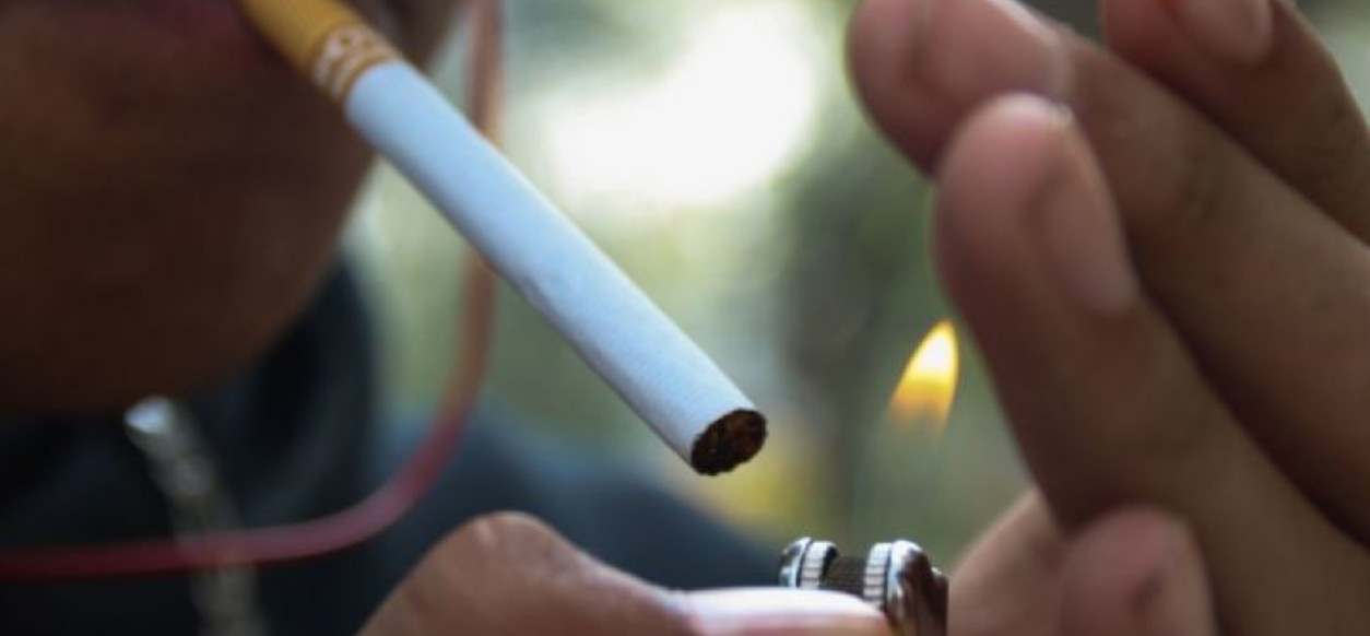 Joven sosteniendo un vapeador y un cigarro.