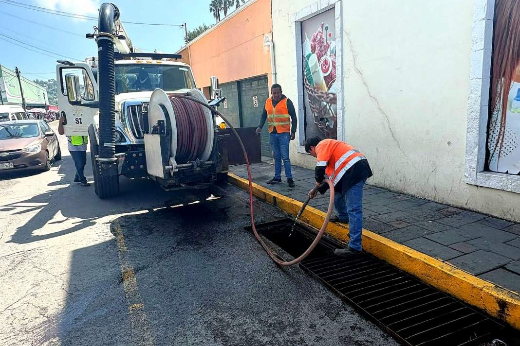 Personal municipal limpia una rejilla de drenaje en el Centro Histórico de Tlaxcala.