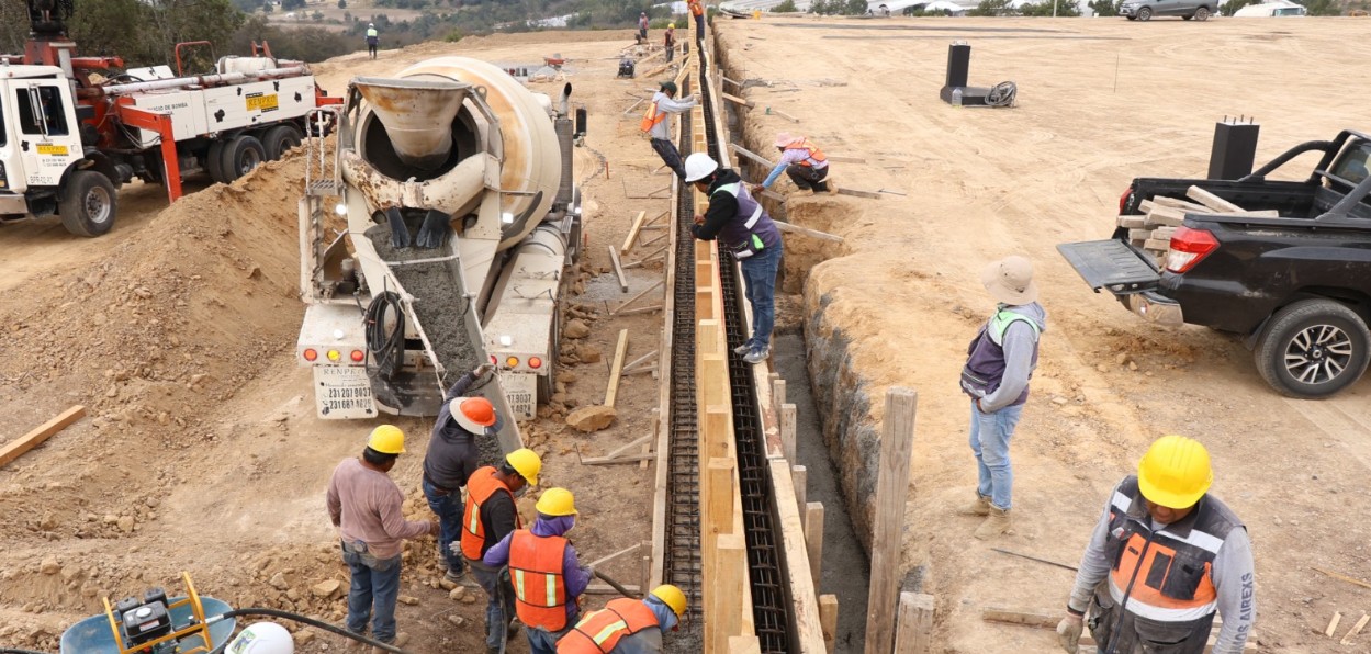 Construcción del CITRAA en Aquixtla con maquinaria y estructuras en obra.