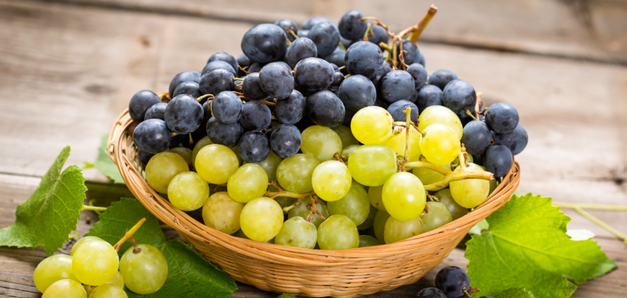 Racimo de uvas junto a accesorios para hacer ejercicio.