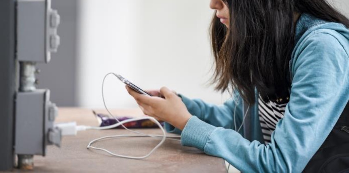 Niño usando un teléfono celular con redes sociales bloqueadas.