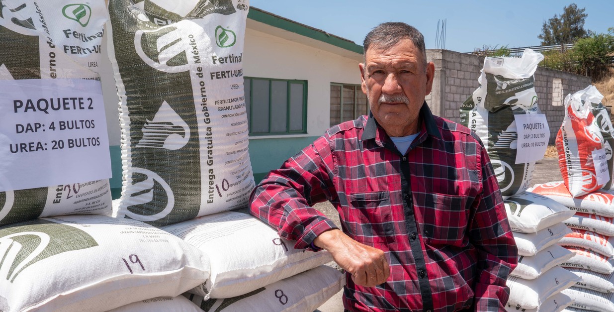 Productores agrícolas reciben fertilizantes del programa gubernamental en un centro de distribución