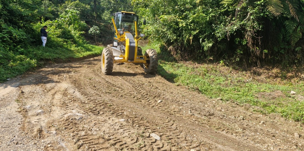 Maquinaria trabajando en la rehabilitación de un camino rural en Nauzontla, Puebla