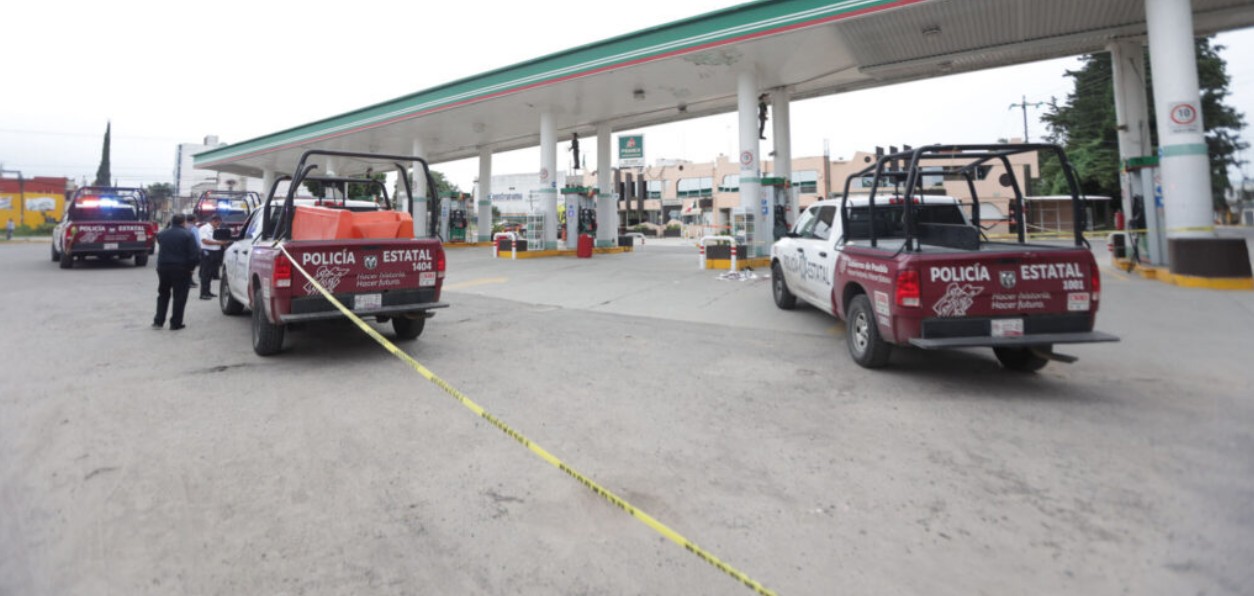 Patrullas afuera de una gasolinera tras un robo en Puebla.
