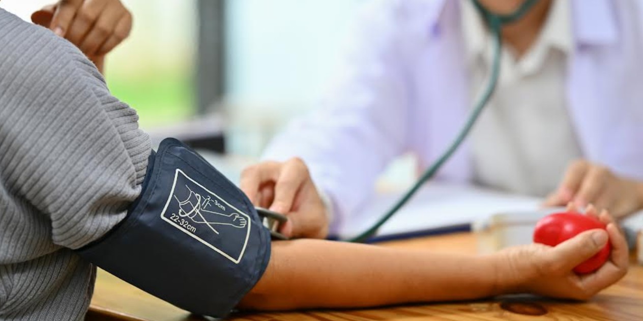 Persona tomándose la presión arterial en consulta médica