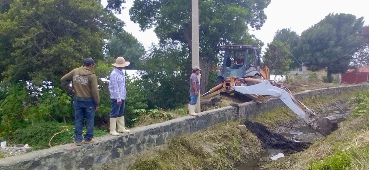 Trabajadores realizando limpieza en canal de riego en Atlixco