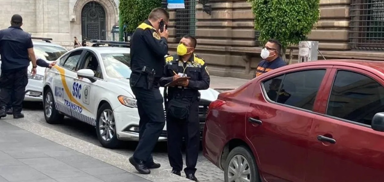 Conductor usando celular mientras maneja en una avenida de CDMX