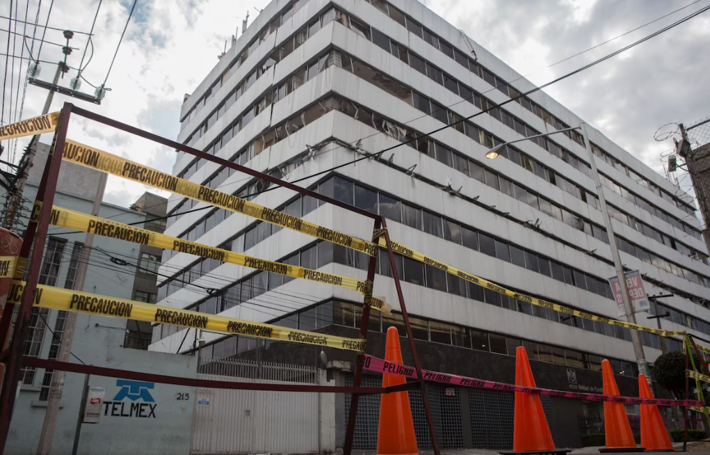 Persona resguardada durante un sismo en un edificio alto.
