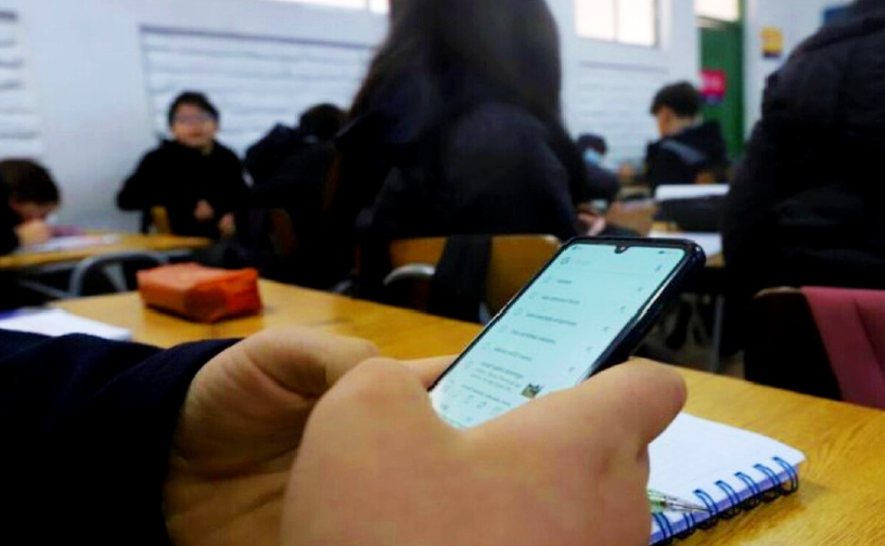 Estudiantes usando celulares en un salón de clases