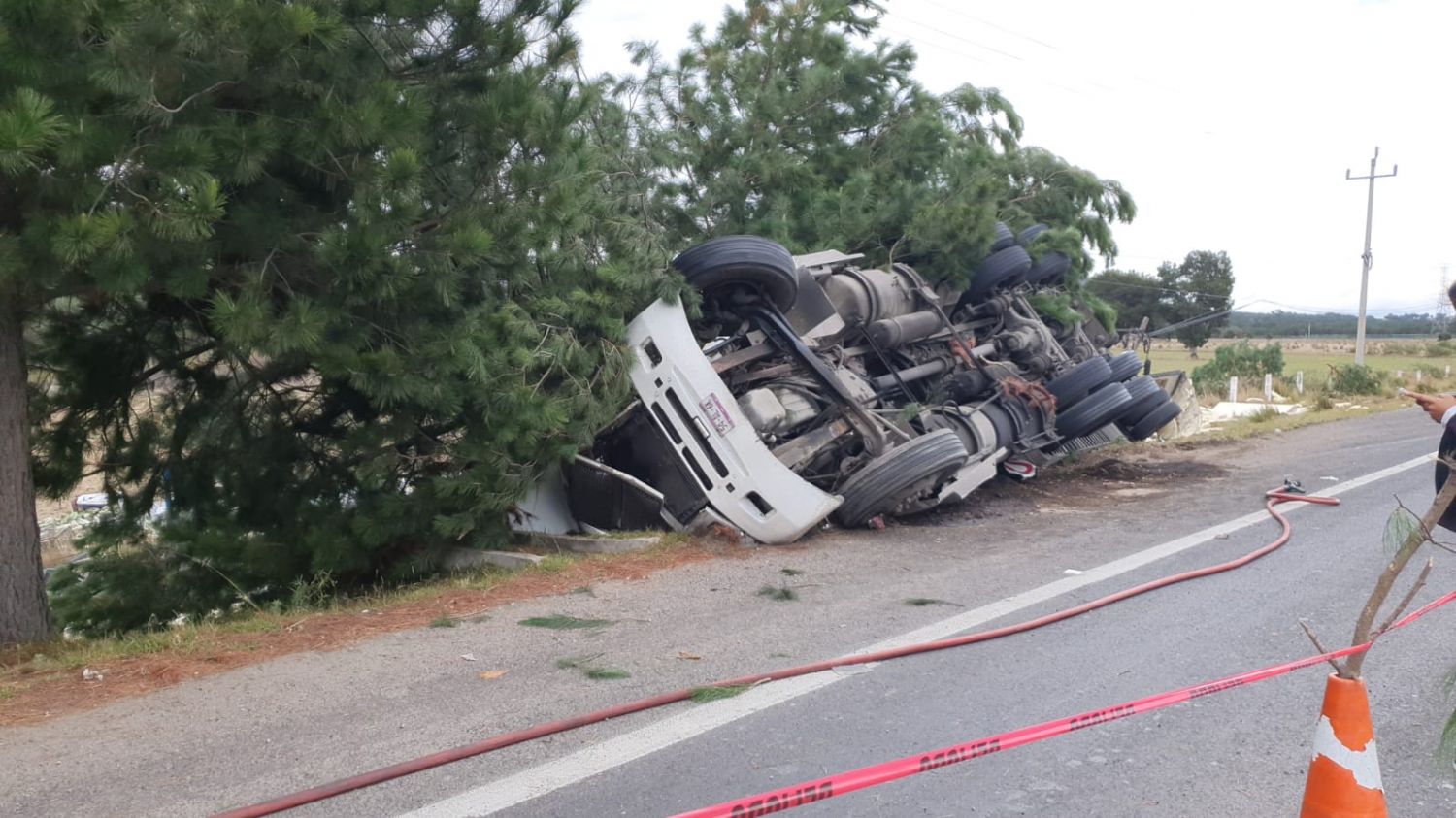 Muere operador de tráiler tras volcar y chocar contra árboles, en Tetla