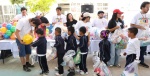 Niños recibiendo juguetes en evento escolar