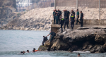 Militares y migrantes en la frontera de Ceuta entre España y Marruecos.